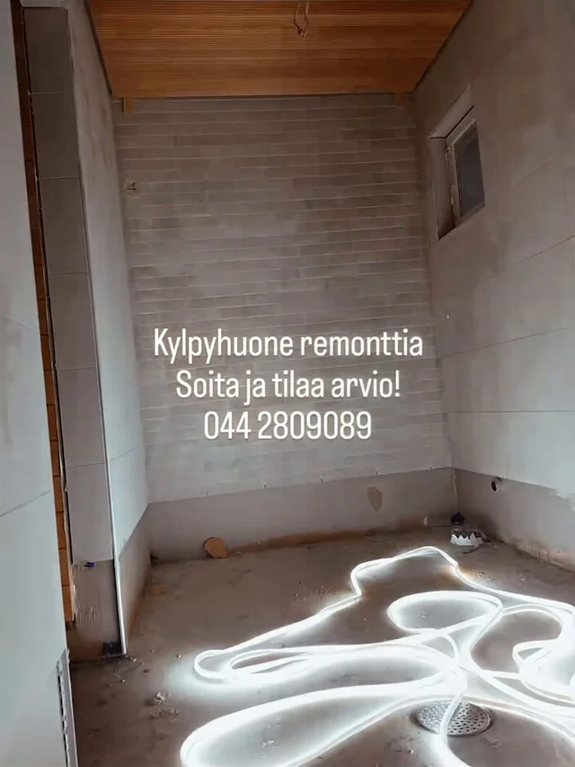 Märkätilan laatoitetut seinäpinnat ja keskeneräinen lattia lattiakaivoineen.